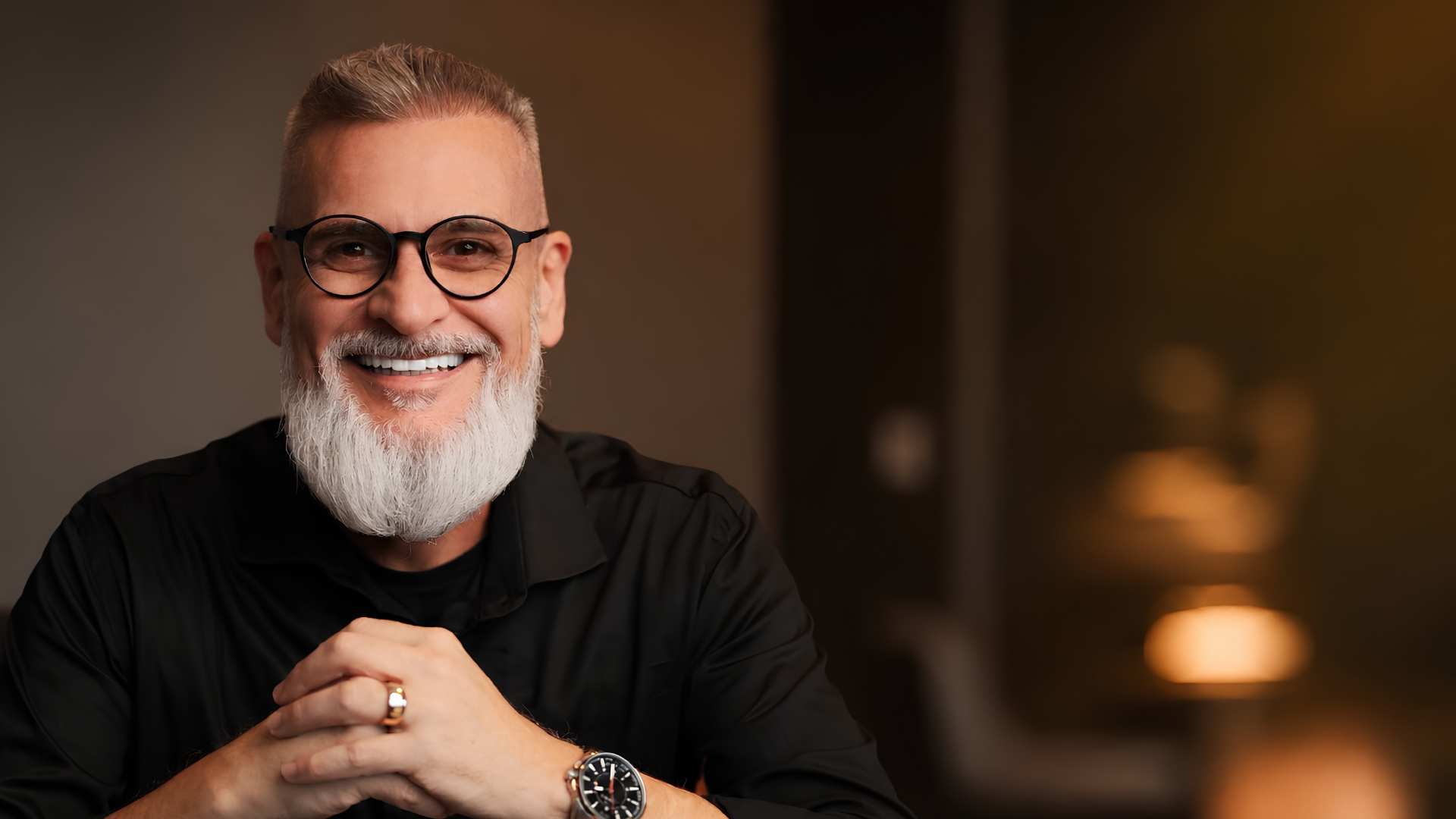 Alexandre Pscheidt sorrindo em um ambiente de iluminação acolhedora